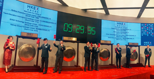 21-3 7 月12 日，港交所8 家公司同时参加敲钟仪式，两家公司同敲一锣，前所未见。坊间戏称，港交所的锣都不够用了。摄影 王云长