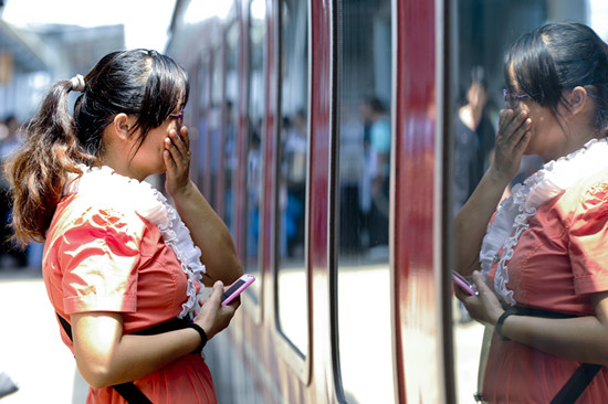 2014年08月27日，广东省东莞市，开学季即将到来时，许多暑假来东莞和父母团聚的小朋友又的踏上回家的列车了。在东莞东火车站，一位妈妈在向自己的小孩告别。_副本