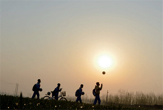 p46 3月25日清晨6点，山东商河县孙集镇中心小学足球队的学生，带着足球去上学。他们每天7 点要参加足球训练课。校长说，农村孩子也能快乐踢球、健康成长。