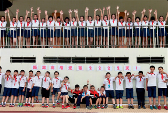 p40-1 6月3日，广西柳州某小学，六年级的学生拍摄创意毕业纪念照，打出了“距离高考还有2222天”标语。
