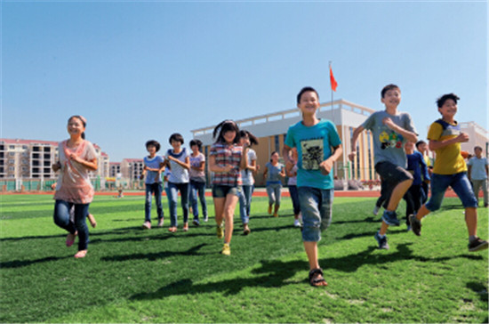 p111-3淮南凤台凤凰中学新校园内，孩子们在快乐奔跑。