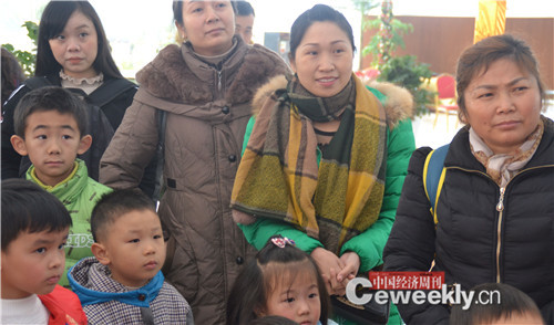 家长和小朋友一起听老师讲参加游戏规则   记者张晓峰摄