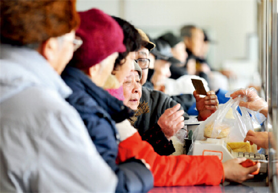 P52-1 2011年2月10日中午，北京西城区月坛街道白云观社区居民在国家广电总局302食堂就餐。302食堂原本是国家广电总局机关家属区的内部食堂，后与月坛街道一起，尝试与社区居民资源共享。对于行动不便的老人，食堂还提供送餐入户服务，送餐覆盖周边13个社区，平均每天入户达100多次。