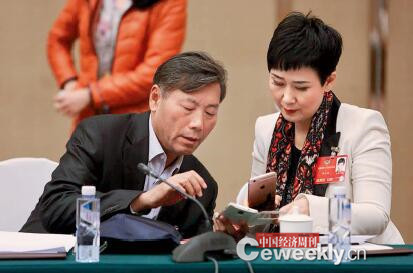 P60-3中国铁路总公司原副总经理胡亚东（左）与中国大唐集团公司副总经理李小琳在会议间隙互相添加微信好友。