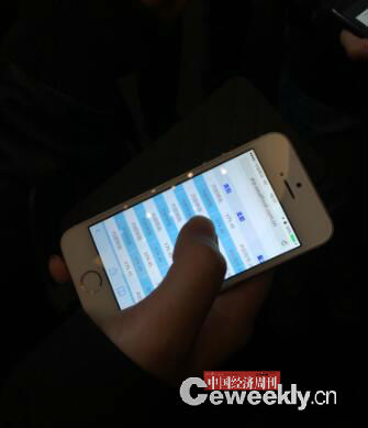 一位投资人向中国经济周刊-经济网记者展示其手机中6日早上收到的中晋理财产品的利息。摄影|宋杰