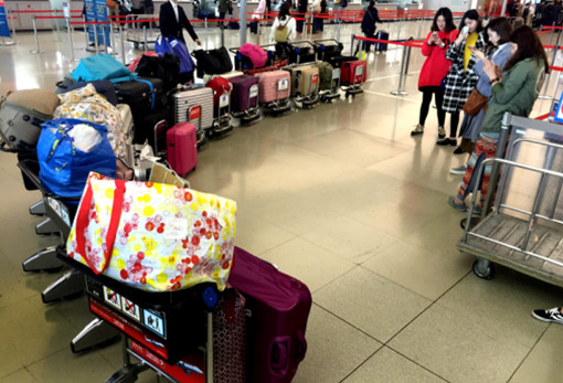 p56 2016 年3 月1 日，几名女孩在机场将满载的行李箱排起长队拍照留念。CFP