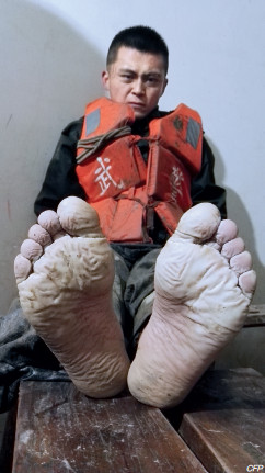 p47 7 月3 日，安徽安庆，武警安徽总队第一支队战士焦磊在两条板凳上小憩，他的双脚已经在洪水里连续浸泡了19 个小时。