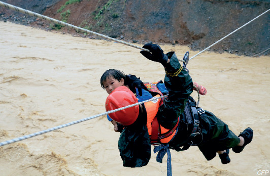 p46(2) 7 月1 日夜至2 日，贵州省榕江县遭受特大暴雨袭击，暴雨引发山洪，消防队员将一名小女孩抱在胸前进行营救。