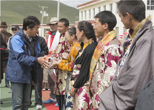 中国摄影家协会副主席、“公益光影助学工程”委员会名誉主席王悦给助学班的孩子们捐助相机
