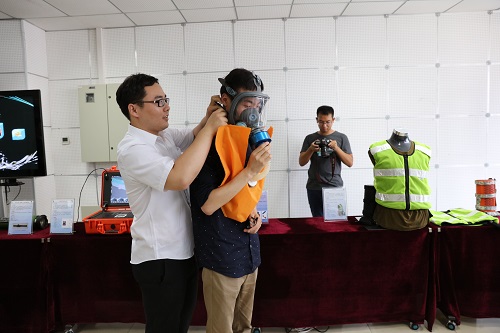 中国经济周刊党员在体验无源增氧呼吸装置。该装置可将人体呼出的二氧化碳转变为可供呼吸的氧气，应对火灾等特殊状况。