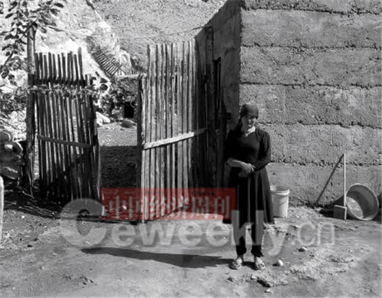 p38-2贫困户买买提明的妻子站在自家的院子里。《中国经济周刊》 记者 曹煦  摄