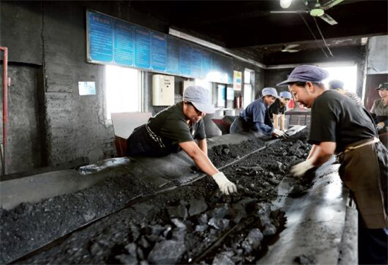 p49 因资源即将枯竭，安徽淮北矿业朔里煤矿计划在明年年底前关井。2016年9月7日，几名选矸女工在运输皮带旁分拣煤炭和矸石。