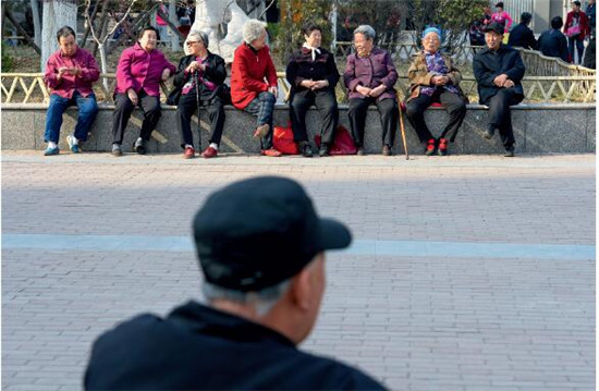 p52 2016年3月31日，河北省石家庄市，一名老人在公园长椅上休息阅读刊物。CFP
