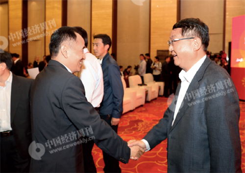 p12(2)《中国经济周刊》总编辑季晓磊（左）与定西市委副书记、市长唐晓明（右）握手致意。