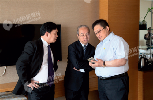 p12(7) 《中国经济周刊》总编助理包锐（右）向榆中农村合作银行董事长周承中（中）展示论坛新媒体报道。