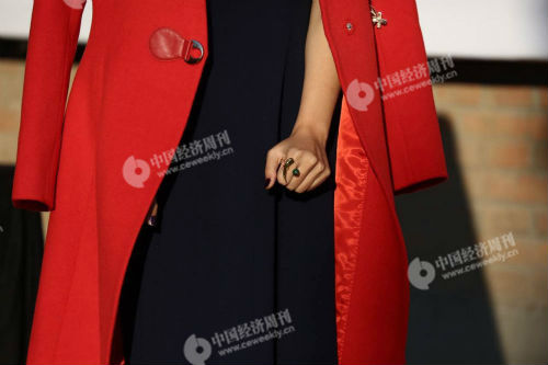 九，前来看秀的艺人潘辰在拍照，穿着潇洒倍显敬业精神，但双手已冻成冰棍，攥紧了拳头。她身后是中国国际时装周（2017春夏）的海报，上面写着37.2摄氏度。