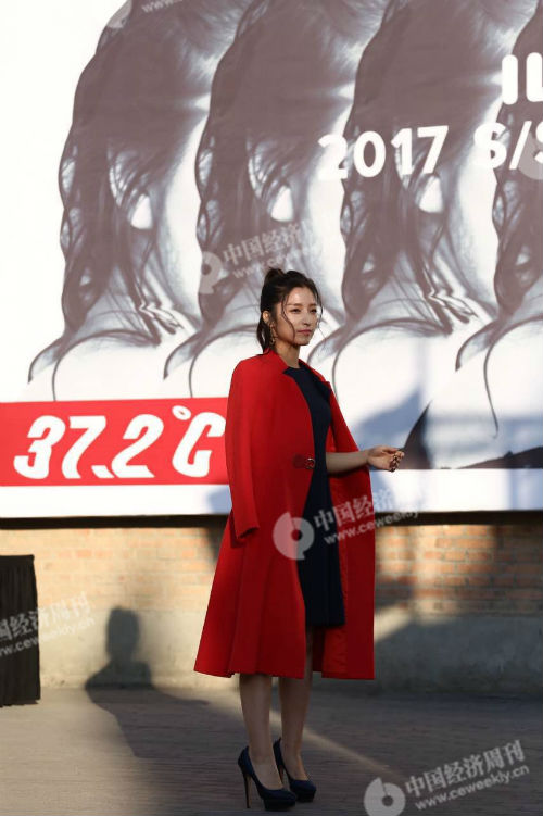 五至九，前来看秀的艺人潘辰在拍照，穿着潇洒倍显敬业精神，但双手已冻成冰棍，攥紧了拳头。她身后是中国国际时装周（2017春夏）的海报，上面写着37.2摄氏度。