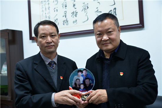 新安县县委书记王玉峰（左）向党员干部赠送廉洁寄语“全家福”