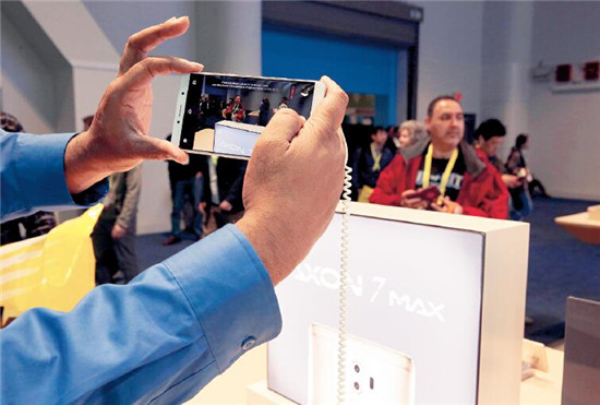 p54 一名参观者在中兴展台试用Axon 7 Max手机的3D拍照，这款手机采用了康得新的全套裸眼3D解决方案。