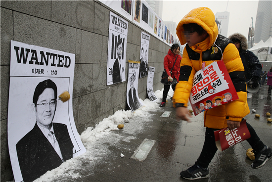 p49 1月21日， 韩国民众计划进行第13次烛光集会，并在墙上贴上三星电子副会长李在镕等“干政门”涉事人的图片，投球出气要求尽快将其逮捕。