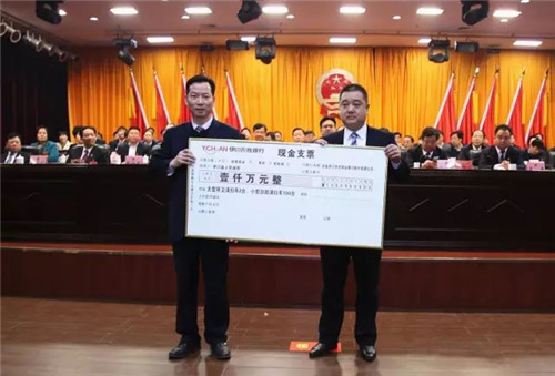 伊川县委常委、常务副县长付晓毅（左）与金辉副行长交接捐赠支票