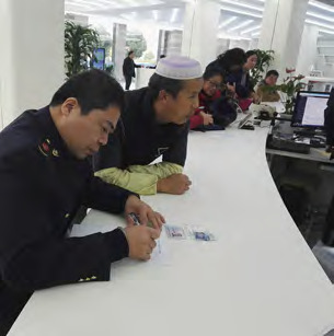 72 江阴市场监管局服务窗口工作人员帮助经营者填写表格 摄影I 耿知秋