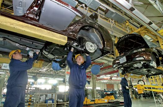 57 浙江吉利汽车有限公司总装二厂工人在车间组装汽车。视觉中国