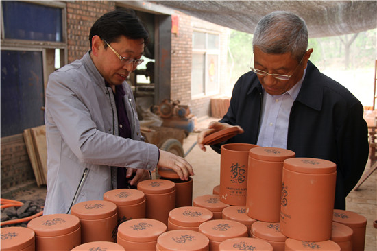 梁衡先生（右）在甘泉村新兴的陶艺企业参观