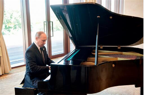 p141 在论坛间隙, 俄罗斯总统普京坐在一处钢琴前即兴弹奏了《莫斯科之窗》等曲目。