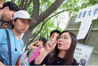44-9 香港回归后，当地大学在内地的招生名额开始逐渐增加。图为2002年5月25日，香港大学和香港中文大学工作人员在北京的招生咨询现场接受咨询。