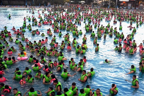 p42 7 月11 日，河南省气象台发布高温橙色预警。一处水上乐园相当火爆，海啸池里挤满了人 。
