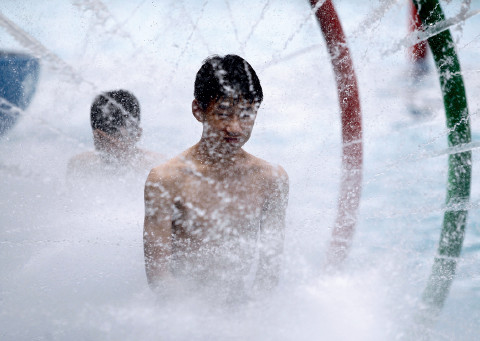 p43(2)重庆主城各大水上乐园吸引了众多游客戏水避暑。