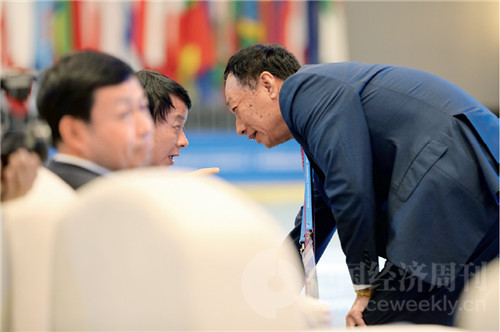 34 鸿海科技集团总裁郭台铭（右）弯着腰和与会嘉宾交流。
