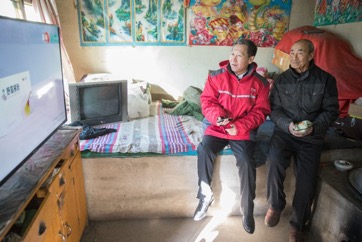 京东集团党委书记龙宝正帮老人调试新装的电视机