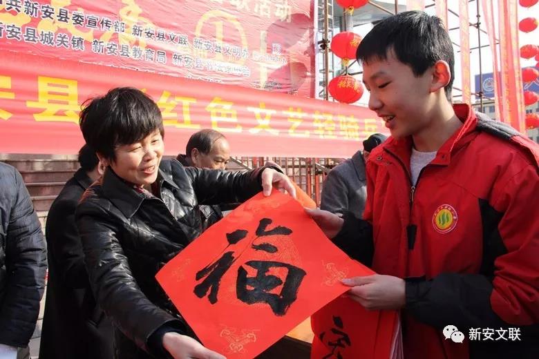1 新安县委常委、宣传部长崔玲（左）向群众赠“福”