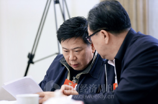 p81 全国政协委员、中国太平保险集团董事长王滨（左）在政协经济界别小组讨论会上讨论提案。