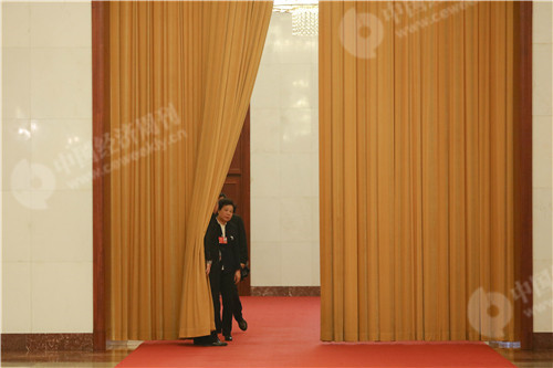83 中国气象局局长刘雅鸣在“部长通道”旁的幕布后张望。