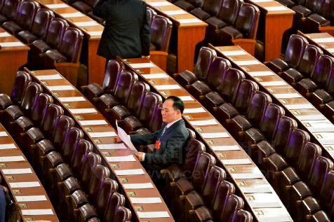 全国人大代表、浙江吉利控股集团董事长李书福，在会议开始前早早到达，在座位上阅读资料。
