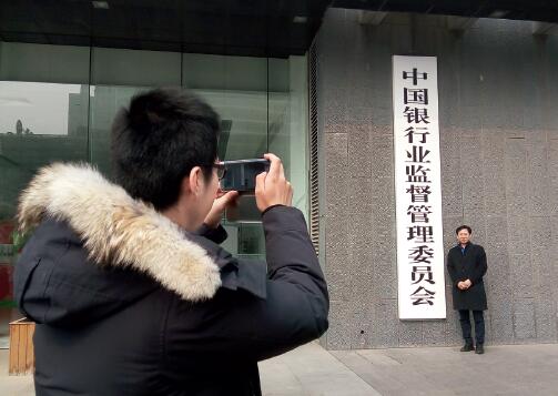 p60-银监会、保监会合并的消息爆出后, 不少民众在银监会摘牌前拍照留念。视觉中国