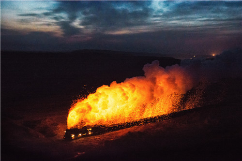 36 2018年1月14日，一列蒸汽机车运行时未燃尽的煤渣经烟管一并排出，犹如“喷火”，在黑暗中照亮了地面。傍晚时爬坡喷火是新疆哈密三道岭蒸汽机车的特色。