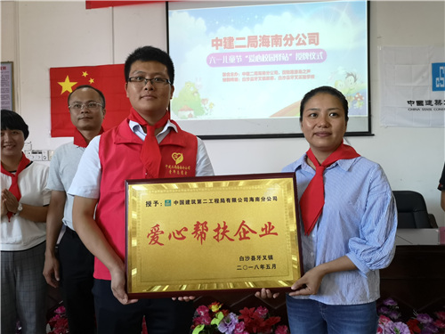 中建二局海南分公司党支部书记、总经理押晓飞（左）接受赠予的“爱心帮扶企业”奖。