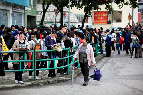 P66越来越多的内地中学生赴香港参加“美国高考”SAT。图为2012年12月，香港SAT考场外，等候进场的考生。 CFP