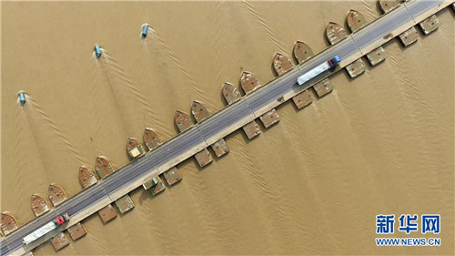 车辆在位于黄河两岸的河南省台前县吴坝镇和山东省东平县银山镇之间的浮桥上行驶（2018年6月26日无人机拍摄）。新华社记者 冯大鹏 摄