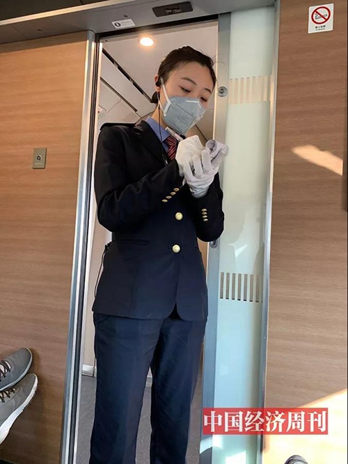 高铁列车上，乘务员佩戴双层手套为旅客服务。