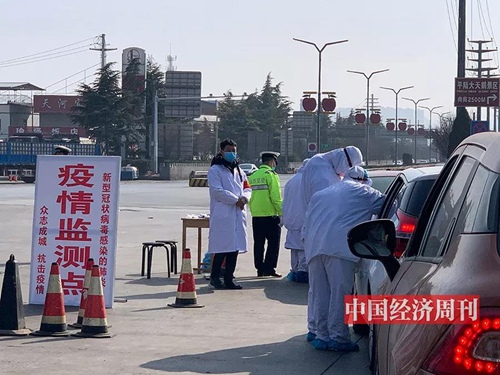 平陆县城高速路口，工作人员测量体温并登记。