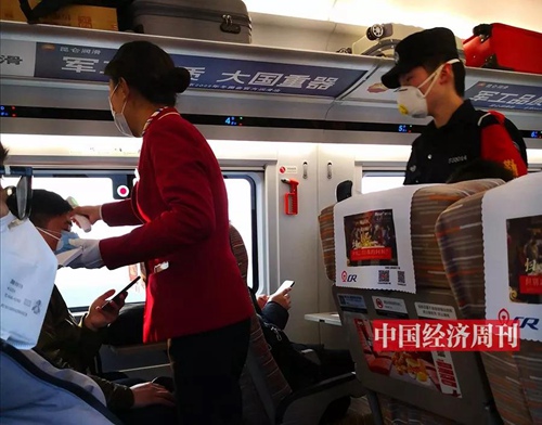 列车员为乘客检测体温。
