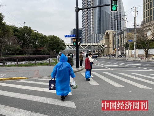 3月3日上海多云，出门买菜的上海市民把雨披当作防护服。（宋杰摄影）