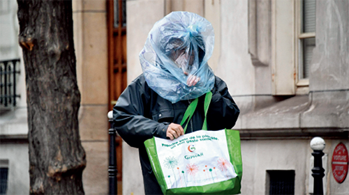 p96 3 月21 日，在法国巴黎，一名行人用塑料袋做防护。新华社