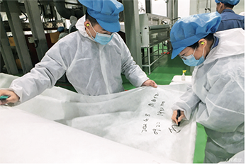 33 2020年4月8日，工人在北京燕山石化生产出的KN95口罩专用熔喷布上做标记。