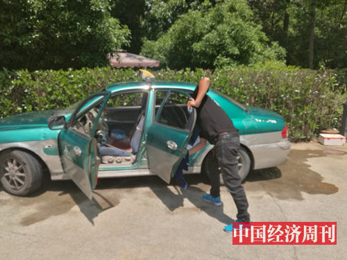 王生（化名）在擦洗自己的出租车 《中国经济周刊》记者 陈一良 摄